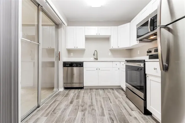 a kitchen with stainless steel appliances granite countertop a refrigerator and a stove top oven