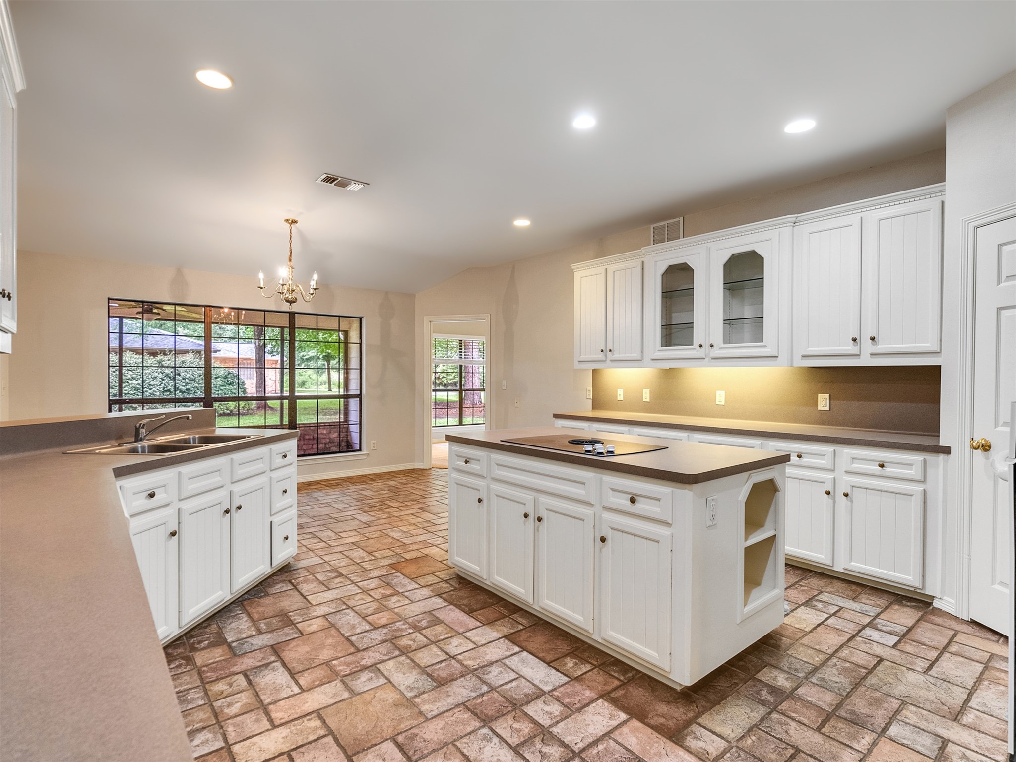 195 Coral Gables Trinity, TX 75862 - Photo 9 of 50 a large kitchen with granite countertop a stove top oven a sink a dining table and chairs
