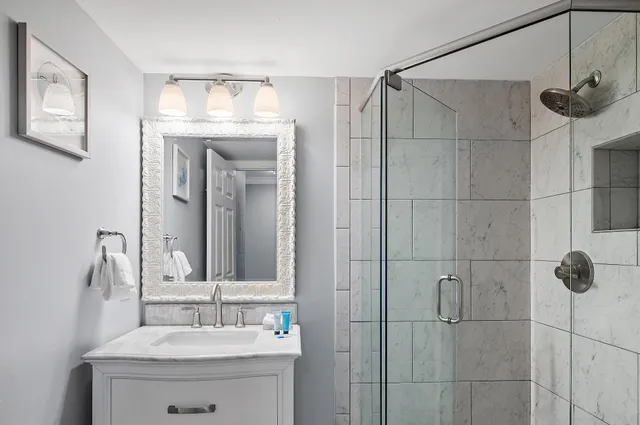 a bathroom with a sink vanity and shower