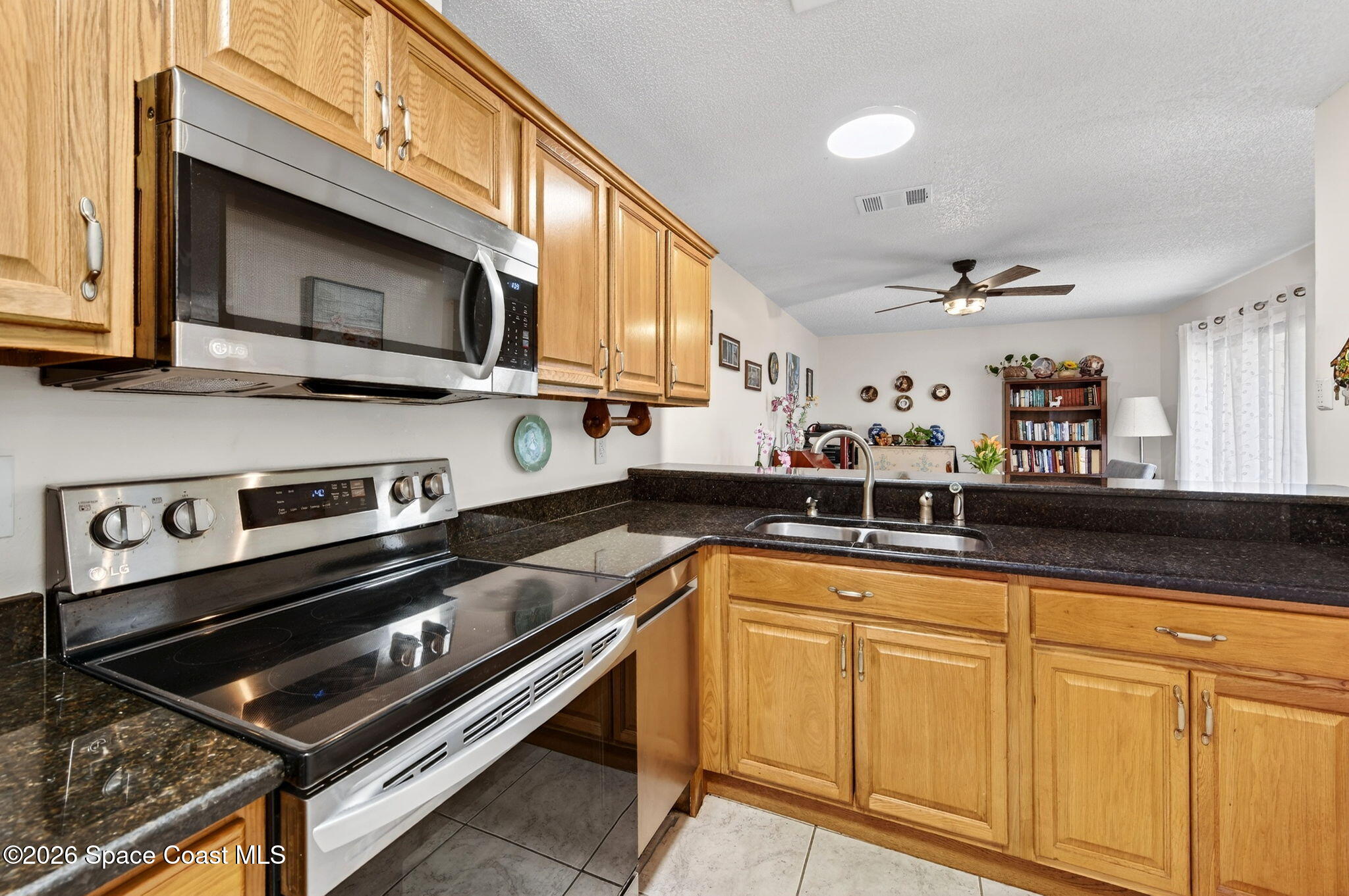 1400 Sheafe Avenue Northeast, Unit 110 Palm Bay, FL 32905 - Photo 11 of 35 a kitchen with stainless steel appliances granite countertop a sink a stove and cabinets