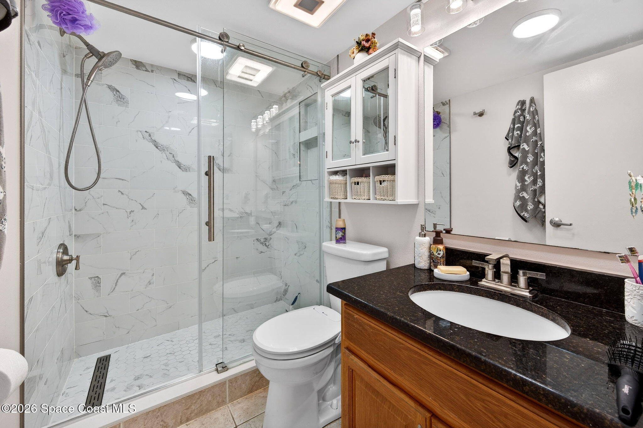 1400 Sheafe Avenue Northeast, Unit 110 Palm Bay, FL 32905 - Photo 21 of 35 a bathroom with a granite countertop sink a toilet a mirror and shower