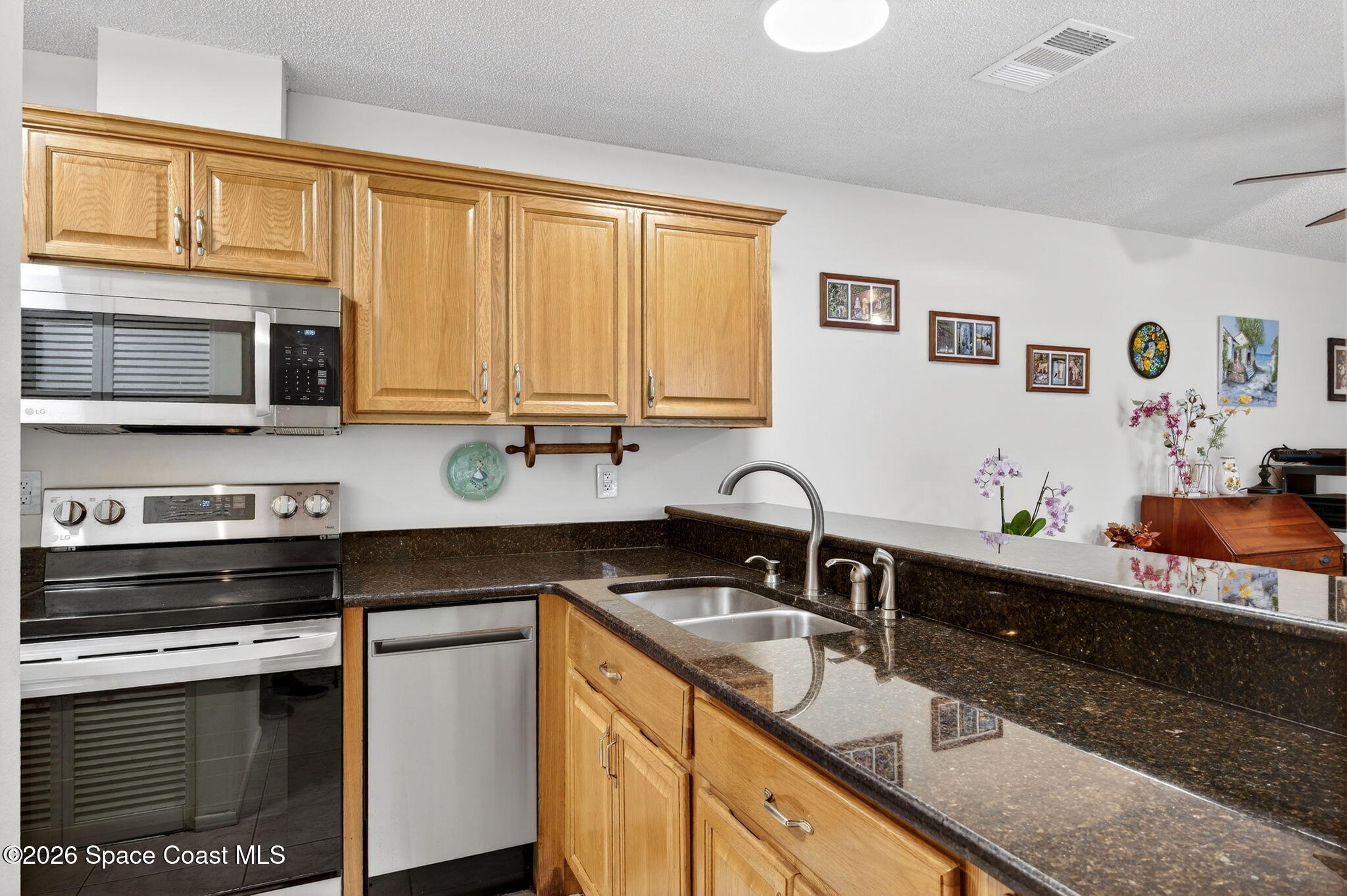1400 Sheafe Avenue Northeast, Unit 110 Palm Bay, FL 32905 - Photo 10 of 35 a kitchen with stainless steel appliances granite countertop a sink stove and microwave