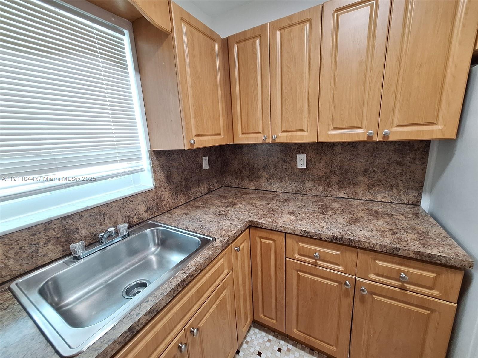 2011 Bay Drive, Unit 3 Miami Beach, FL 33141 - Photo 11 of 14 a kitchen with granite countertop white cabinets and sink