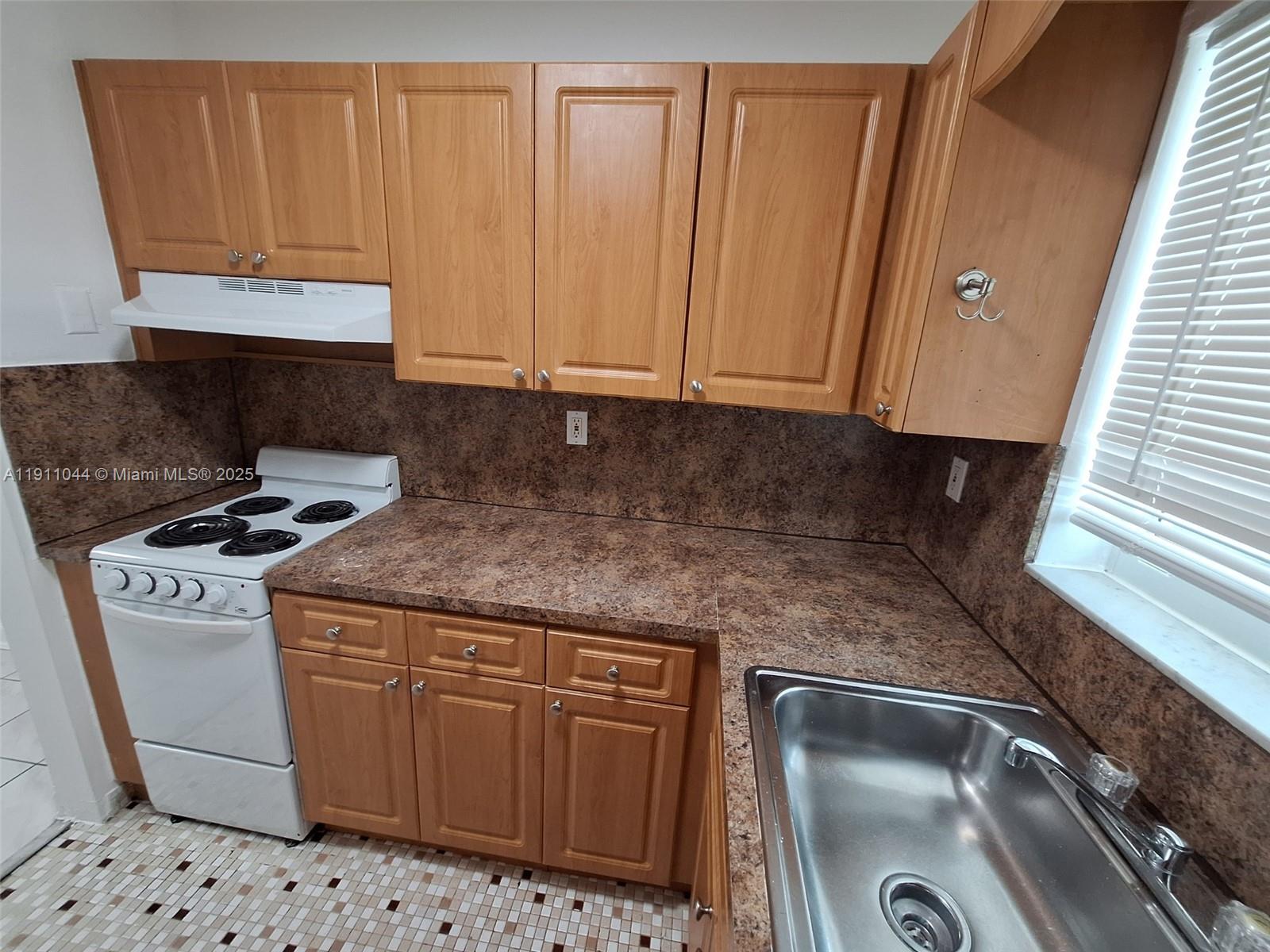 2011 Bay Drive, Unit 3 Miami Beach, FL 33141 - Photo 12 of 14 a kitchen with granite countertop a sink a stove and a microwave
