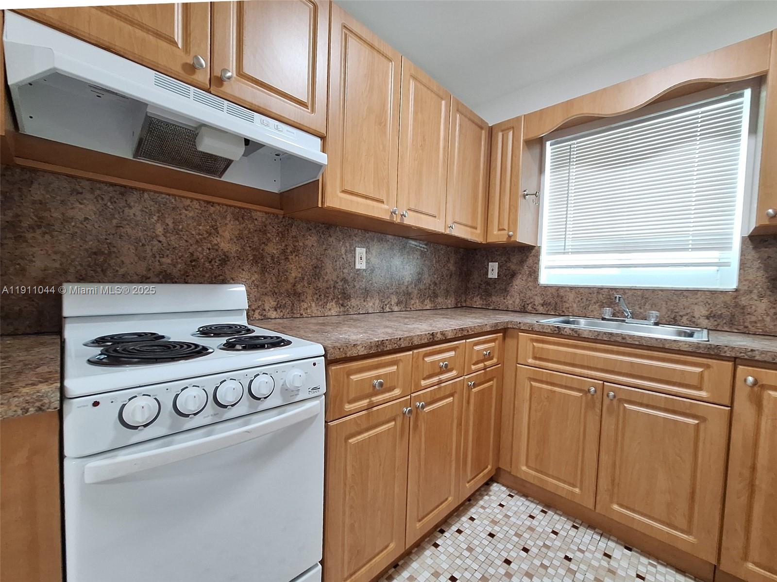 2011 Bay Drive, Unit 3 Miami Beach, FL 33141 - Photo 13 of 14 a kitchen with a stove and white cabinets