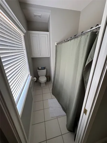 a bathroom with a sink a toilet a window and vanity