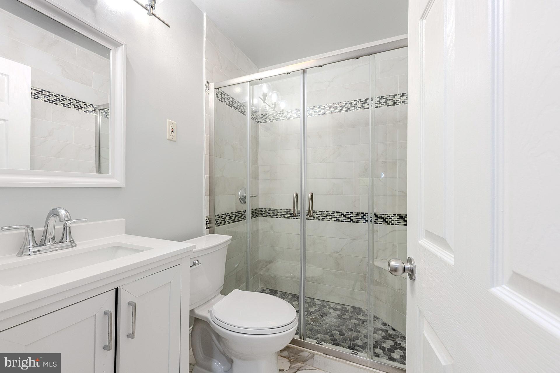 5807 Accomac Street Springfield, VA 22150 - Photo 39 of 50 a bathroom with a shower sink vanity and toilet