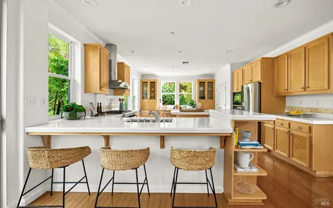 a kitchen with granite countertop white cabinets and chairs