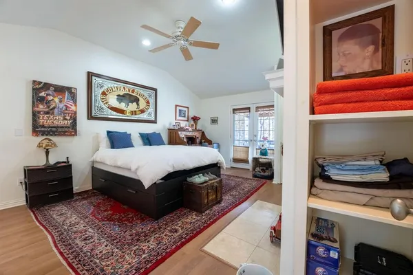 a bedroom with a bed a dresser and painting on the wall