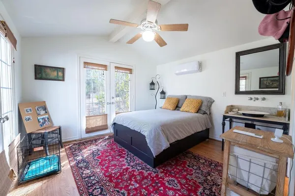 a bedroom with a bed a dresser next to a window