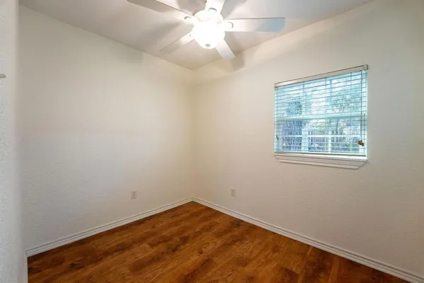 an empty room with a window and a fan