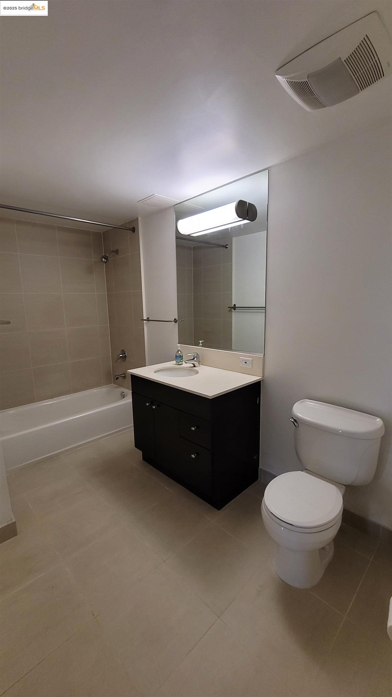 311 Oak Street, Unit 816 Oakland, CA 94607 - Photo 12 of 20 a bathroom with a toilet a sink and mirror