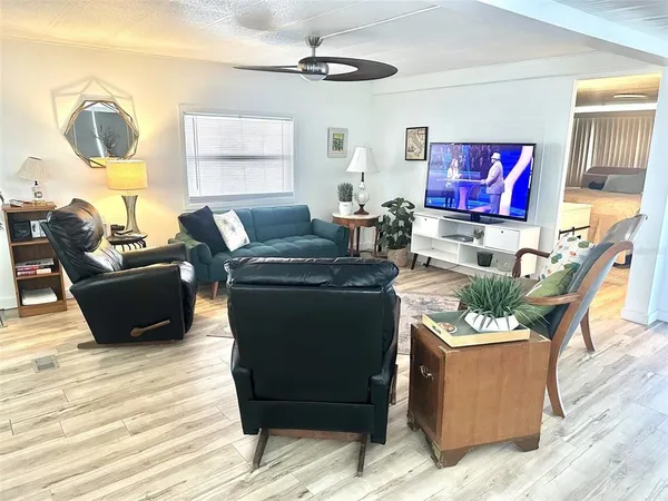 a living room with furniture potted plant and a large window