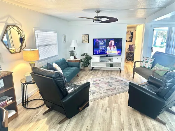 a living room with furniture a flat screen tv and a window