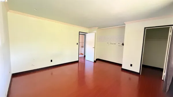 an empty room with wooden floor and closet