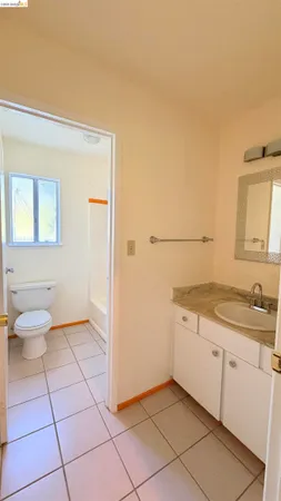 a spacious bathroom with a granite countertop sink a toilet and a mirror