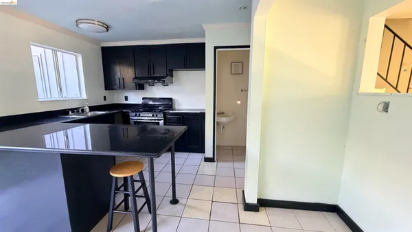 a kitchen with granite countertop a refrigerator a stove a sink a microwave and dining table