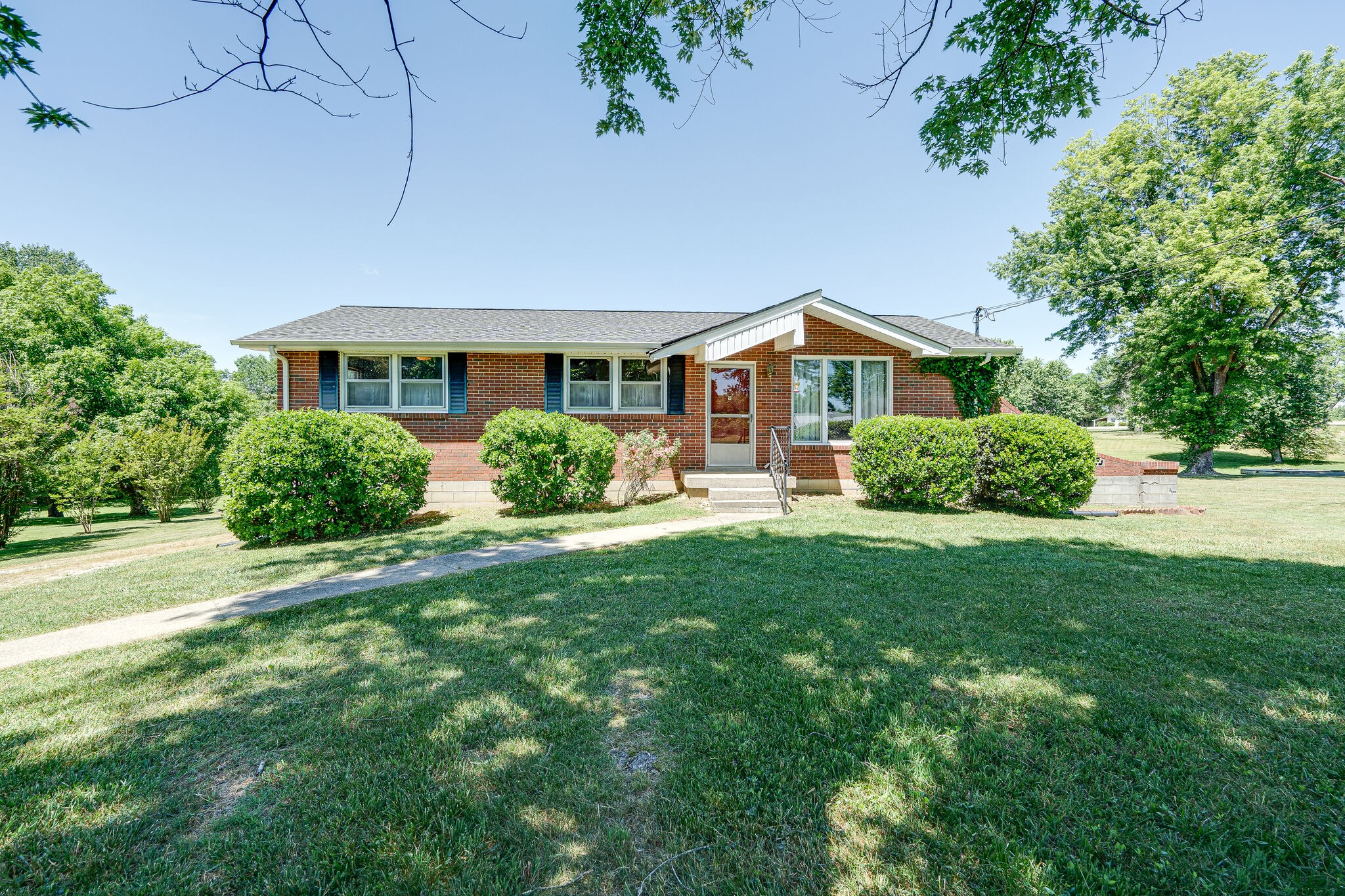 a front view of a house with a yard and potted plants