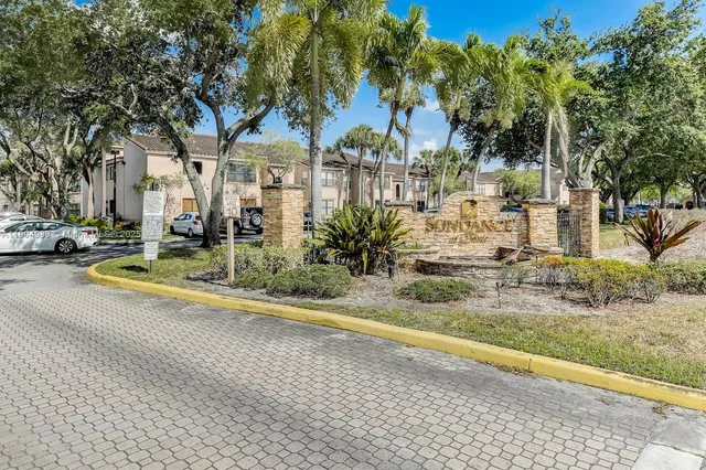 a view of a house with a yard and large trees