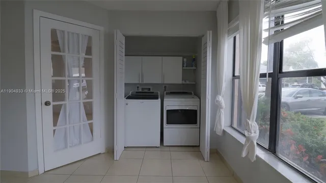a kitchen with a refrigerator and white cabinets