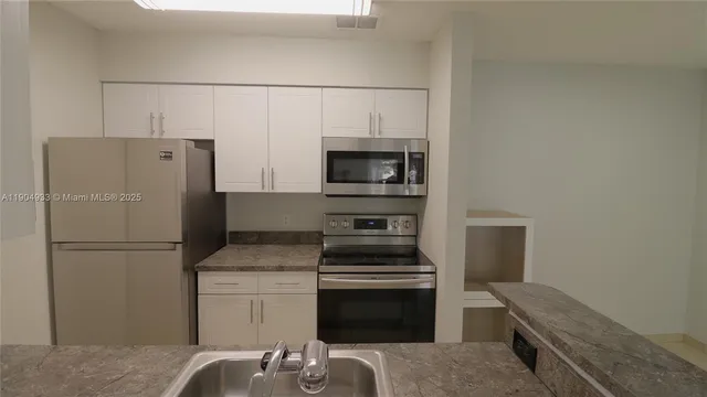 a kitchen with a refrigerator stove and microwave