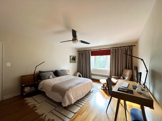 a bedroom with a bed window and a desk
