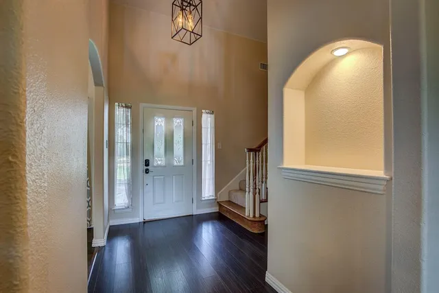 a view of a room with wooden floor mirror and windows