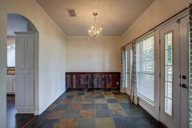 a view of a hallway with wooden floor and a chandelier