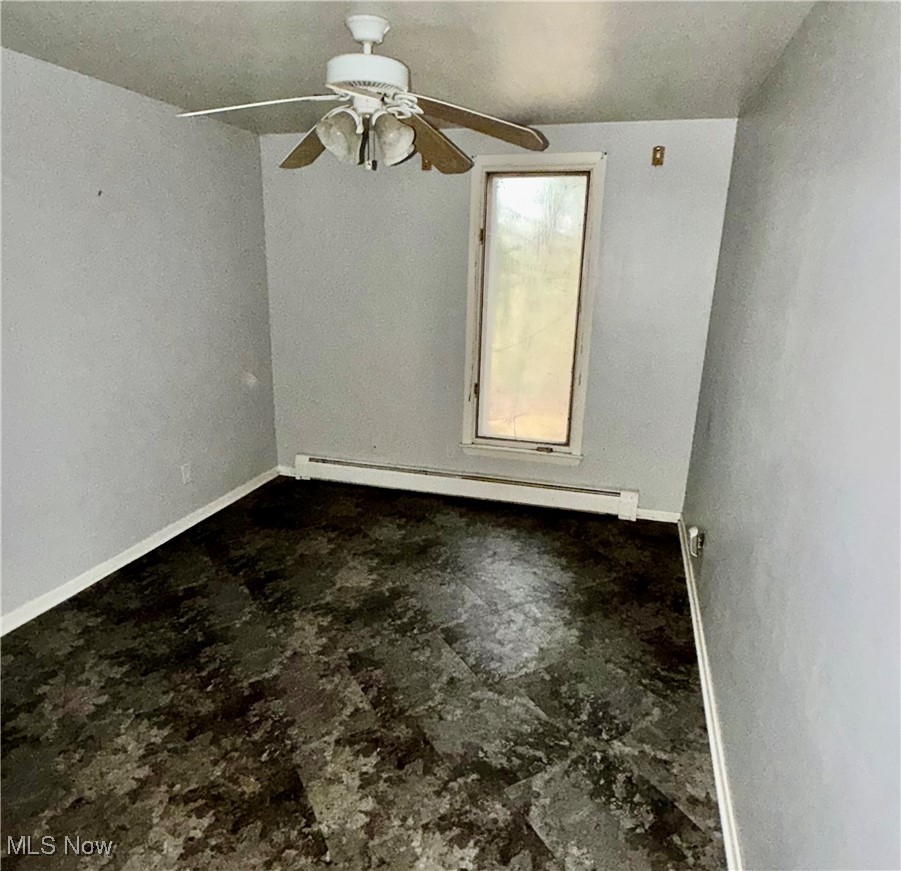 2898 Canton Road Uniontown, OH 44685 - Photo 18 of 20 Empty room with a baseboard radiator and a ceiling fan