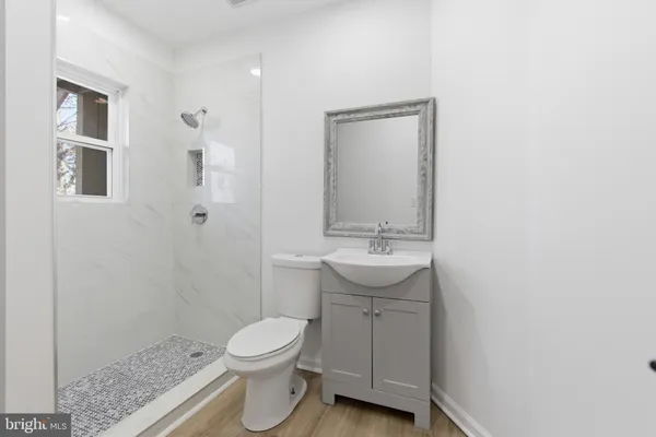a bathroom with a sink a toilet and shower