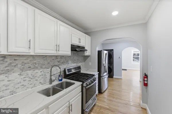 a kitchen with white cabinets and stainless steel appliances