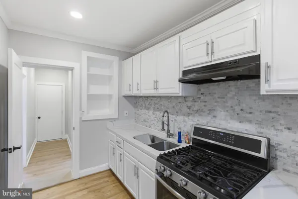 a kitchen with white cabinets and appliances