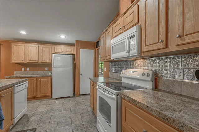 a kitchen with stainless steel appliances granite countertop a sink refrigerator and cabinets