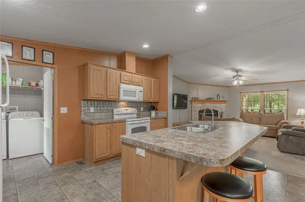 a kitchen with stainless steel appliances granite countertop a refrigerator a stove and a sink