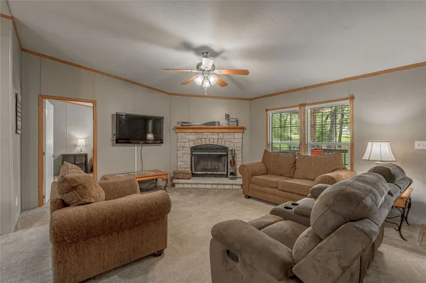 a living room with furniture a fireplace and a large window