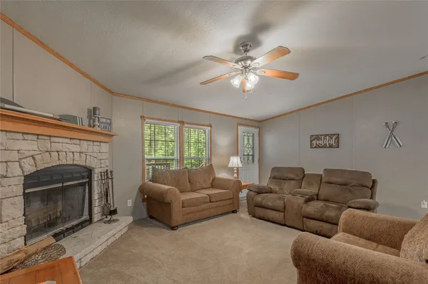 a living room with furniture ceiling fan and a large window
