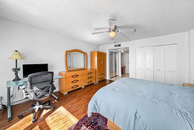 a spacious bedroom with a bed and a chandelier