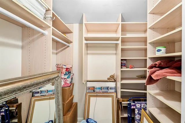 a view of walk in closet with clothes and shoes