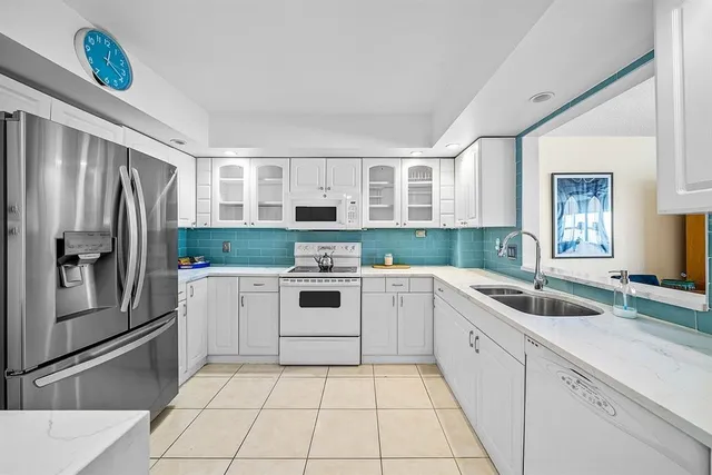 a kitchen with a refrigerator sink and cabinets