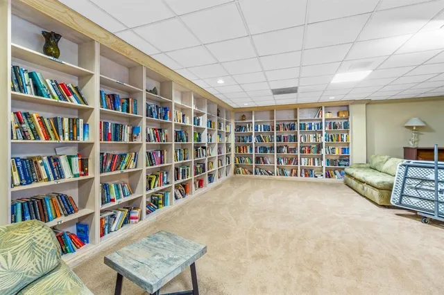 a view of an empty room with furniture and book shelf