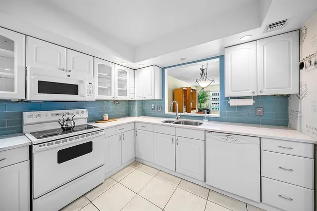 a kitchen with cabinets appliances a sink and a window