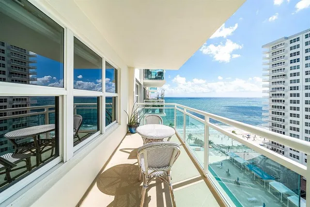 a view of a balcony with dining table and chairs