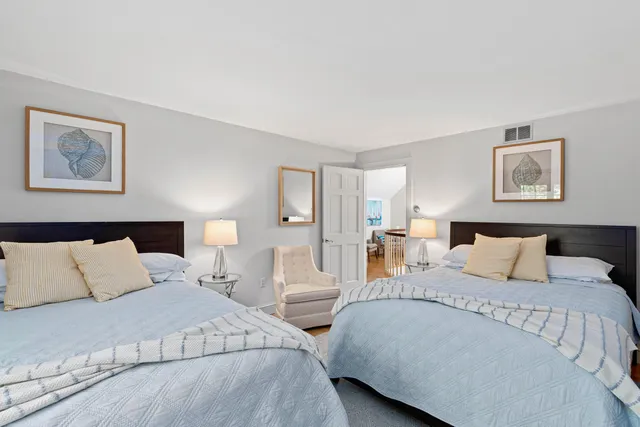 a bedroom with two beds and painting on the wall