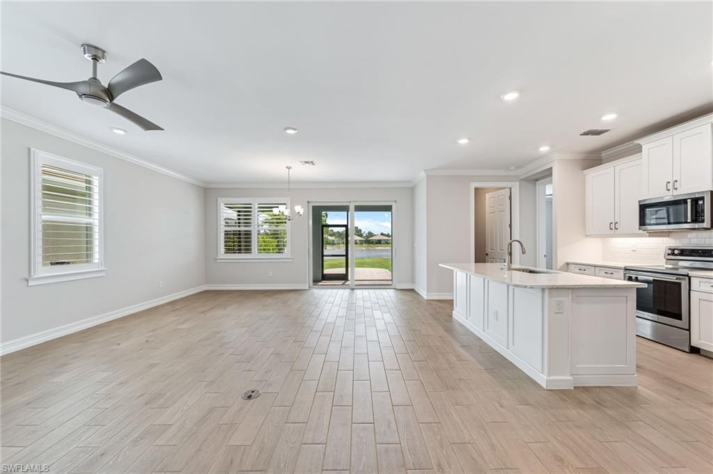 475 Polihale Way Naples, FL 34114 - Photo 3 of 27 a view of an empty room with window and wooden floor