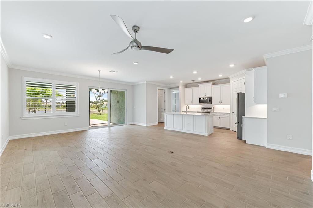475 Polihale Way Naples, FL 34114 - Photo 4 of 27 a view of an empty room with a window and wooden floor