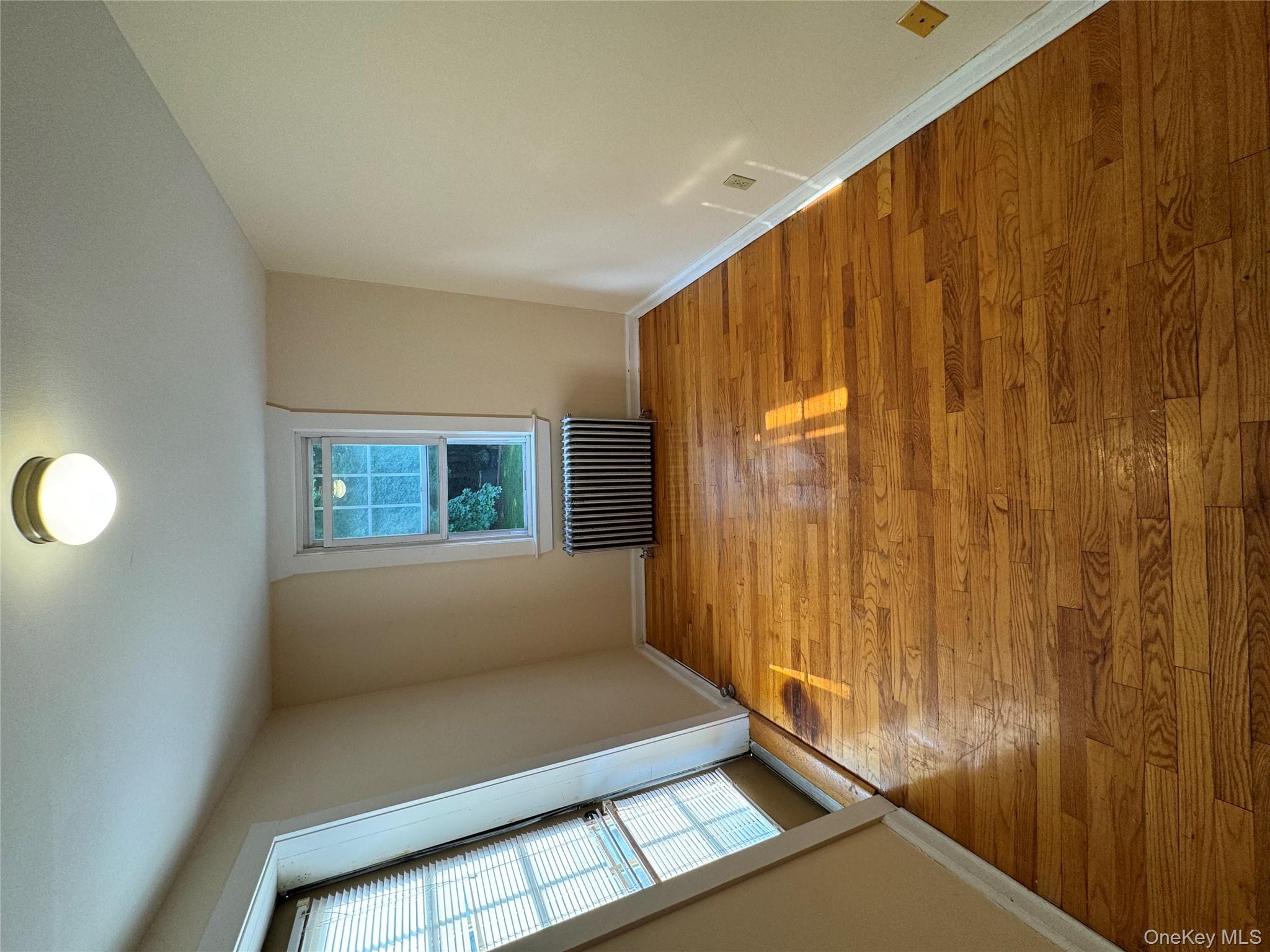 560 State Rte 44 55, Unit D Highland, NY 12528 - Photo 2 of 13 Empty room with radiator heating unit and light wood-style flooring