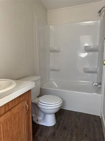 a white toilet sitting next to a bath tub