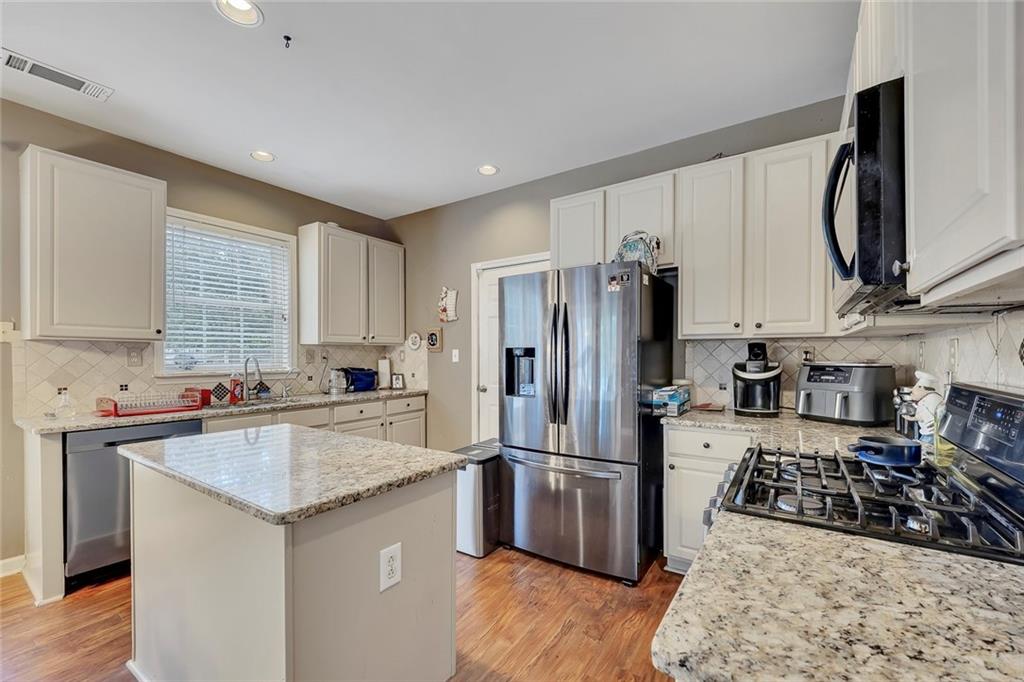 785 Hedgewick Trail Alpharetta, GA 30022 - Photo 14 of 32 a kitchen with granite countertop a sink stainless steel appliances and counter space