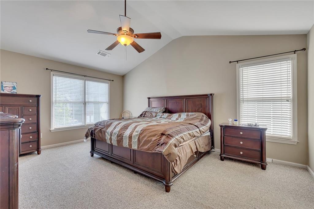 785 Hedgewick Trail Alpharetta, GA 30022 - Photo 20 of 32 a spacious bedroom with a bed and a chandelier