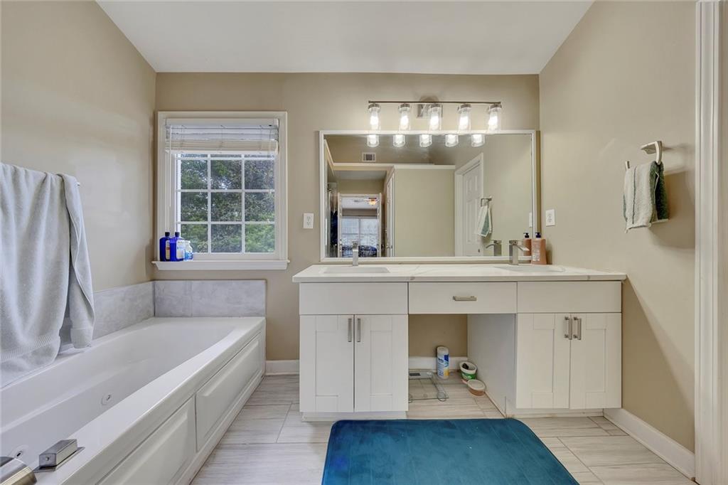 785 Hedgewick Trail Alpharetta, GA 30022 - Photo 23 of 32 a bathroom with a tub sink and mirror